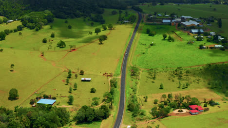 Camino-Rural-Idílico-Entre-Campos-Verdes-Y-Vegetación-En-Las-Mesetas-De-Atherton,-Queensland,-Australia---Toma-Aérea-De-Drones