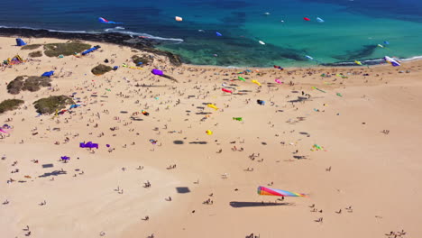 kite-fest-fuerteventura,-Spain-,-festival-de-cometas-,-kite-in-turquoise-water-and-white-beach-in-canary-island,-drone-4K-footage