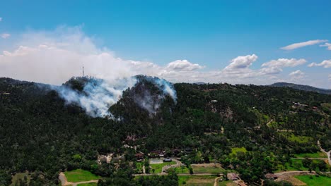Air-pollution-due-to-a-forest-fire-in-the-mountains,-wildlife-and-nature-destruction-due-to-human-inconsistency,-aerial-drone-view