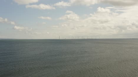 Luftaufnahme-Eines-Leeren-Meeres-Mit-Einem-Windpark-Und-Dem-Oosterschelde-Sturmflutwehr-Am-Horizont