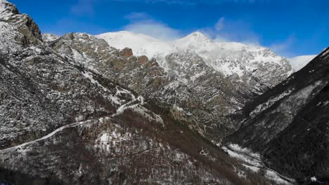Antenne:-Schneebedeckter-Berghang-Mit-Schneebedeckten-Bergen-Im-Hintergrund