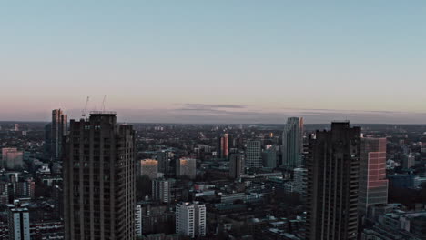 Rising-drone-shot-of-Barbican-towers-framing-north-London-early-morning