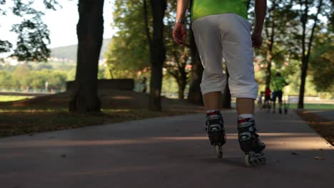 Close-up-of-person-roller-skating-through-a-city-park