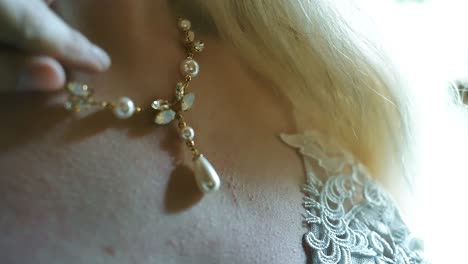 Close-up-of-bride-adjusting-a-necklace-on-her-wedding-day