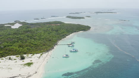 AERIAL---Overview-of-boats-and-island,-Cayo-Icacos,-Puerto-Rico,-high-angle-pan-right