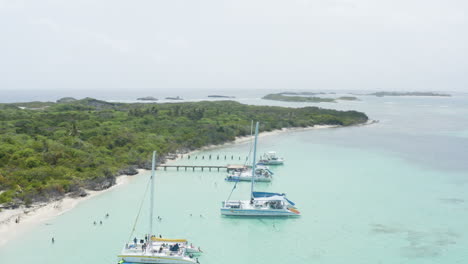 AERIAL---People-on-boats-on-clear-waters,-Cayo-Icacos,-Puerto-Rico,-rising-circle-pan