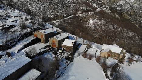 Antenne:-Verschneite-Bergstadt-An-Einem-Berghang-In-Den-Katalanischen-Pyrenäen-Mit-Einem-Mann,-Der-Schnee-Entfernt