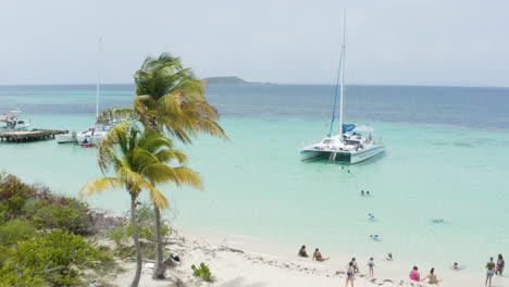 AERIAL---People,-catamaran-boat,-turquoise-waters,-Cayo-Icacos,-Puerto-Rico,-forward