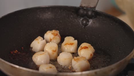 Stationary-close-up-shot-of-fresh-scallops-sizzling-with-hot-oil-on-teflon-coated-shallow-frying-pan,-seafood-cooking-concept