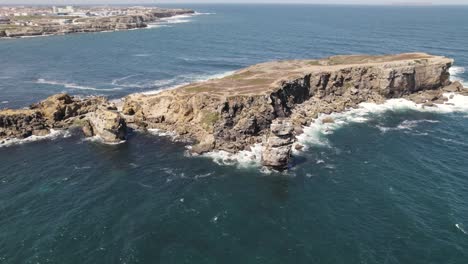 Atlantic-sea-waves-crashing-on-rocky-headland-cliffs,-Peniche,-Portugal