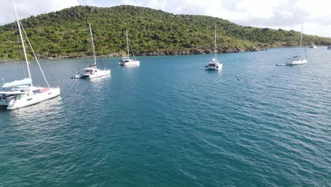 exciting-low-flying-aerial-of-a-bay-and-sailing-yachts-in-the-British-Virgin-Islands,-sailing-hotspot