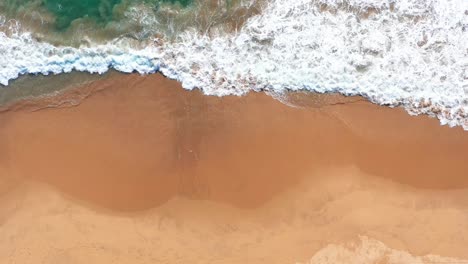 Aerial-topdown-view-tropical-beach-waves-splashing-the-sand-shore,-Pie-de-la-Cuesta,-Acapulco-Guerrero,-Mexico