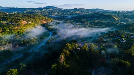 Morning-fog-in-the-countryside-with-a-river-and-mountains,-stunning-environment-in-a-caribbean-country-Dominican-Republic,-amazing-scene
