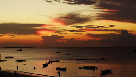 Zeitraffer---Schöner-Sonnenuntergang-Am-Strand-Mit-Booten,-Nungwi,-Sansibar,-Tansania