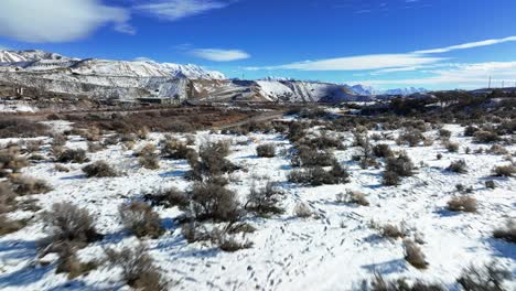 Beautiful-Aerial-View-of-Snowy-Mountains-and-Bushes-in-Bluffdale-Utah---Forward-Reveal