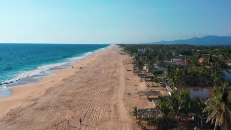 Aerial-flyover-Pie-de-la-Cuesta-beach,-People-playing-with-Glide-kite,-Mexico