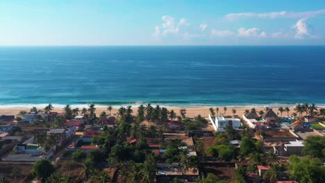 Flyover-Beachfront-houses-towards-blue-Pacific-Ocean-Pie-de-la-Cuesta-beach,-Mexico
