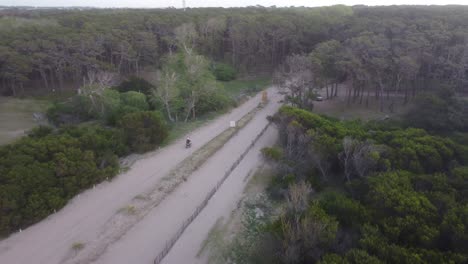 A-motorcycle-rides-down-Mar-de-las-Pampas-into-a-forest
