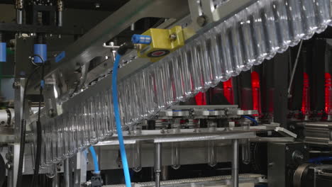 A-glimpse-of-the-plastic-bottle-production-line:-plastic-PET-preforms-are-being-moved-into-the-heating-machine