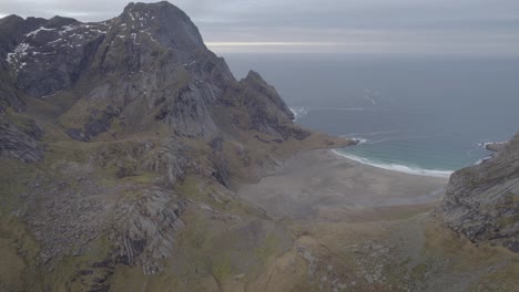 Vista-Aérea-De-Una-Playa,-Entre-Picos-De-Lofoten-Oscuro,-Noruega---Pan,-Tiro-De-Drone