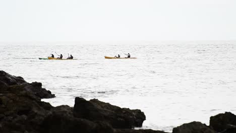Multiple-sea-kayakers-paddling-along-the-bright-horizon-on-the-south-pacific-ocean-near-Quepos,-Costa-Rica