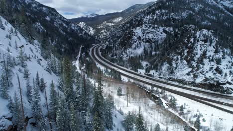 Drone-shot-coming-around-the-side-of-a-mountain-and-revealing-a-highway