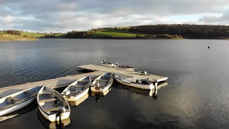 Aerial-forward-shot-of-boats-moored-at-a-pontoon-on-Wimbleball-Lake-Exmoor-England-on-a-sunny-day