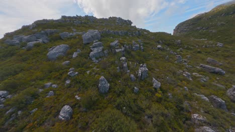 Lange-Luftaufnahme,-Die-über-Die-Spektakuläre-Felsige-Oberfläche-Des-Tafelbergs-In-Kapstadt,-Südafrika,-Und-In-Den-Nebel-Fliegt