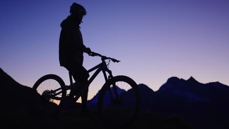 Ein-Mountainbiker-Steht-Bei-Sonnenaufgang-Auf-Einem-Bergrücken