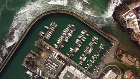 Aerial-minimalist-top-down-of-scenery-harbor-port-with-yacht-boat-moored-in-the-ocean