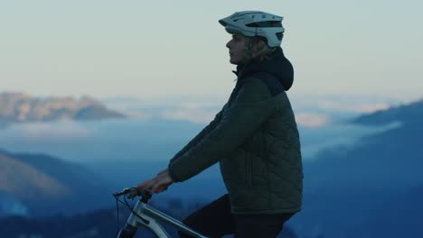 Ein-Mountainbiker-Rastet-Bei-Sonnenuntergang-über-Einem-Wolkenmeer
