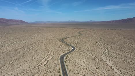 Fahrzeug-Fährt-Auf-Kurvenreicher-Straße-Durch-Joshua-Tree-National-Park,-Mojave-Wüste,-Kalifornien