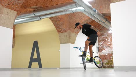 Man-on-a-BMX-bike-riding-indoors-doing-some-tricks