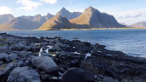 Rocky-coast-with-towering-mountains-on-the-Islands-of-Lofoten,-Norway