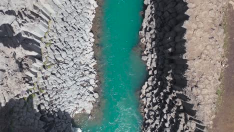 Studlagil-canyon-with-spectacular-turquoise-water-in-Iceland,-top-down-aerial
