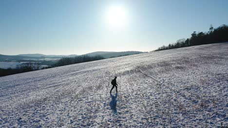 a-man-walking-up-a-frozen-hill---clear-skies-and-sunny