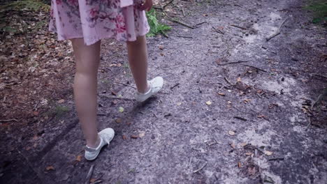 Schnittansicht-Eines-Mädchens-Mit-Kleid-Und-Weißen-Turnschuhen,-Das-Im-Wald-Spazieren-Geht