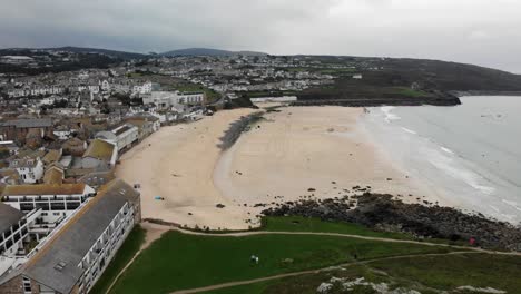 Aerial-forward-shot-of-Porthmeor-Beach-and-St-Ives-town-in-Cornwall-England