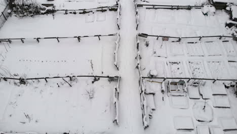 Aerial-View-Of-Community-Farm-With-Paddocks-In-White-Snow-On-A-Winter-Day
