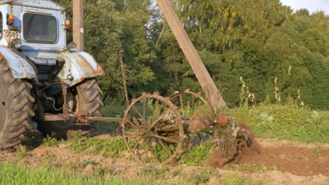 Close-up-camera-shot-of-old-rusty-potatoes-harvesting-machine-still-digging