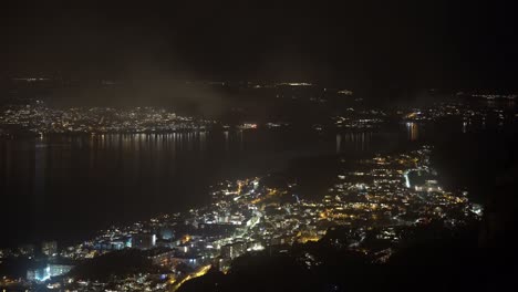 Dark-night-with-occasional-fireworks-in-Askoy-close-to-Sandviken-and-Eidsvaagneset-outside-Bergen---Static-clip-seen-from-mountain-Stoltszen-early-on-new-years-eve
