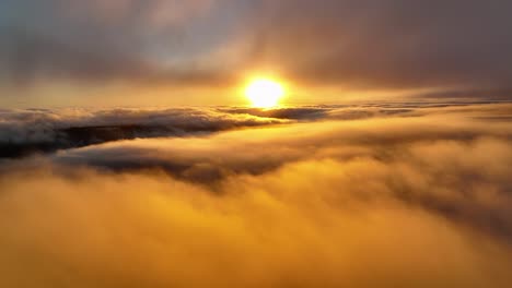Sonnenuntergang-über-Den-Wolken,-Schöne-Luftaufnahme-Von-Rollenden-Wolken-Und-Orangefarbener-Sonne
