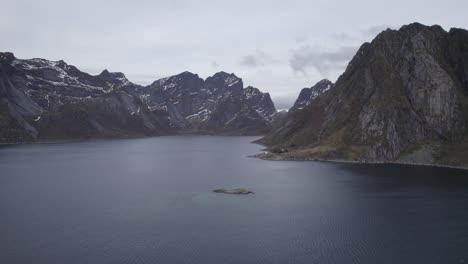 Aerial-view-of-steep-rocky-mountains,-rising-from-the-sea,-fall-day-in-Lofoten,-Norway---ascending,-drone-shot