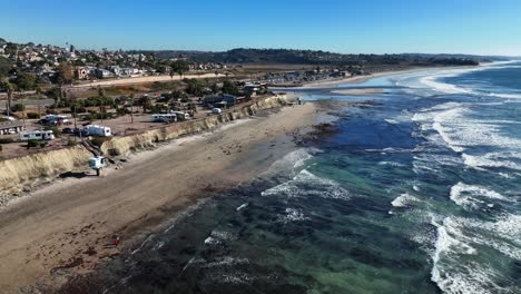 BEACH--aerial-shot-of-an-empty-lonely-sandy-beach-at-the-Cardiff-By-The-Sea-in-San-Diego-California-in-the-soft-morning-light,-flying-low-over-the-breaking-waves-along-the-beach