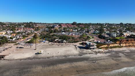 Drohnenaufnahme-über-Der-Stadt-Encinitas,-Kalifornien,-USA-Vom-Moonlight-Beach-Mit-Blick-Auf-Wohnhäuser,-Parkplatz,-Straßen-Und-Erste-Hilfe-Zentrum-An-Einem-Sonnigen-Tag