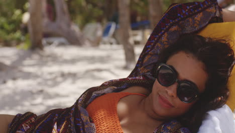 Latin-Brunette-Lady-Relaxing-on-Sun-Lounger-in-the-Shade-Enjoying-Beach-holiday,-Medium-Shot