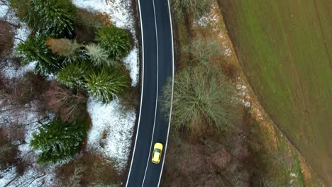 Top-down-view-of-a-car-driving-on-a-road---follow-shot