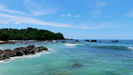 Calm-waves-splash-on-volcanic-rocks-on-paradise-Wediombo-beach,-Java,-Indonesia,-aerial-view