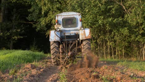 Slow-motion-camera-view-of-old-russian-tractor-harvesting-potatoes