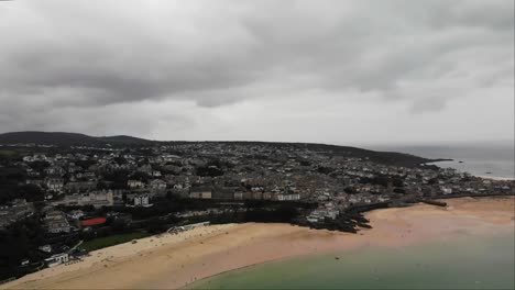 Aerial-panning-left-shot-of-St-Ives-beach-and-harbour-in-Cornwall-on-a-cloudy-day
